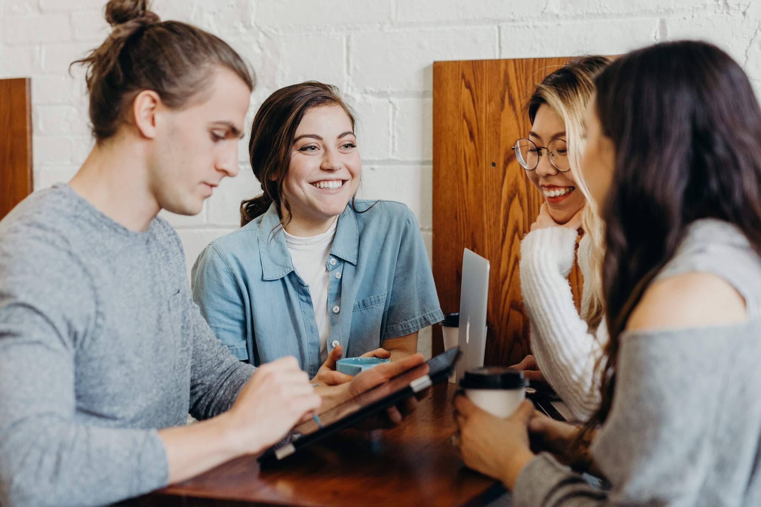 group of students conversing over tablet