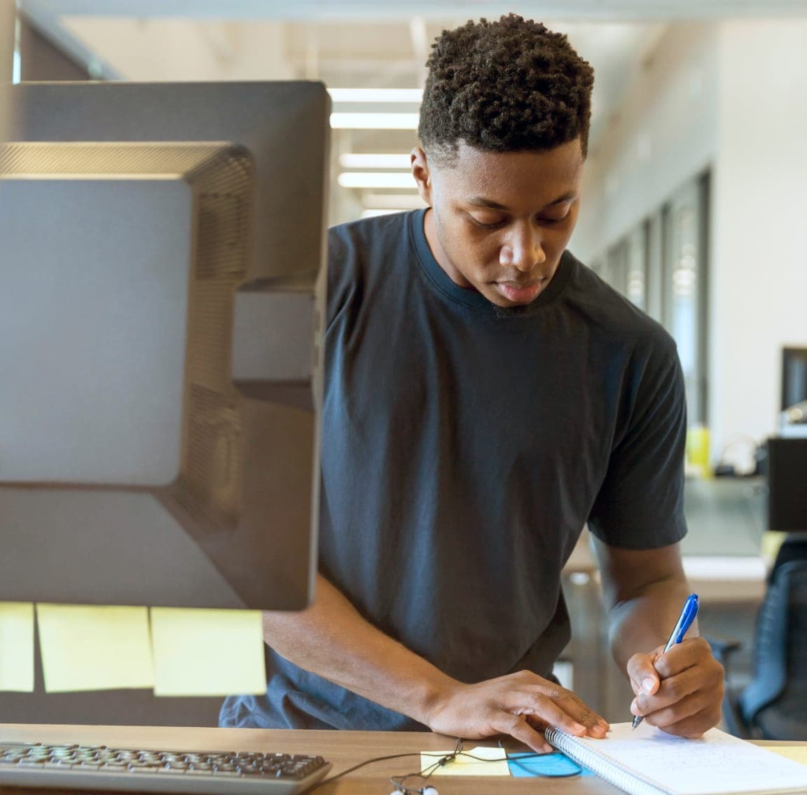 A student taking a note in front of a computer